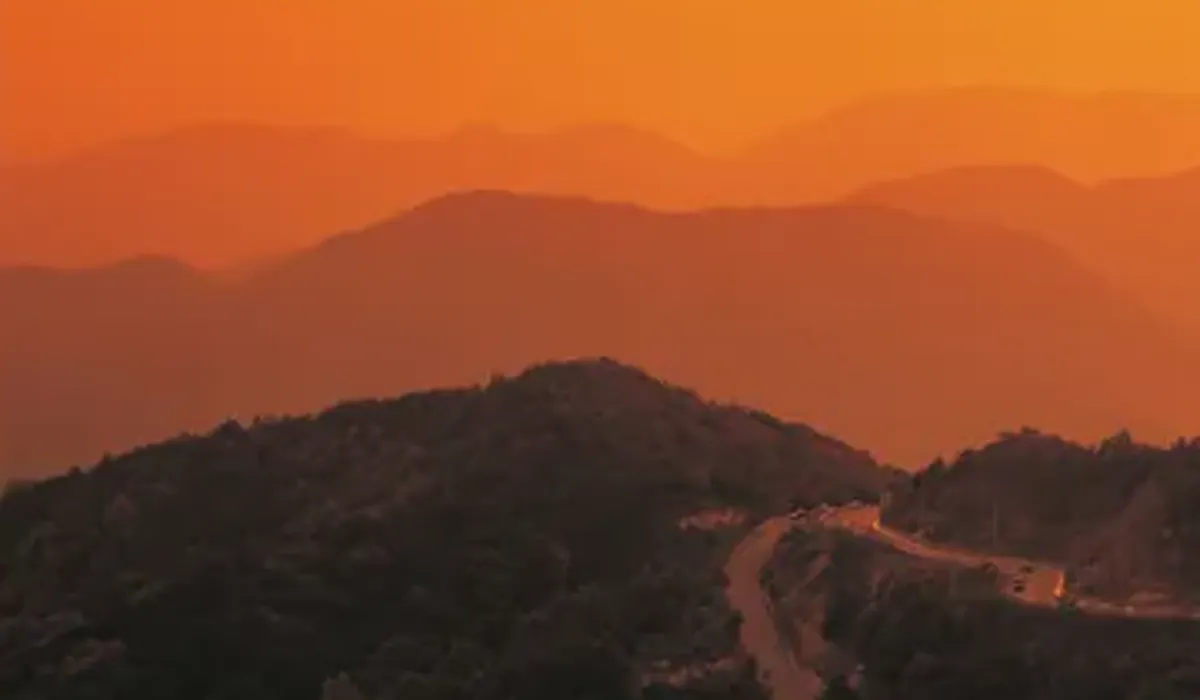 Orange sunset over layered hills